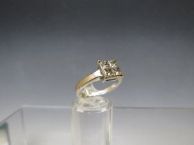 AN 18CT WHITE GOLD FOUR STONE DIAMOND RING, the princess cut stones set in a square, total diamond