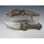 A VINTAGE MIDDLE EASTERN JAMBYA DAGGER, with white metal handled accoutrements and leather covered