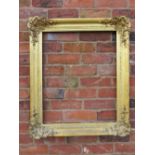 A GILT RECTANGULAR PICTURE FRAME, with foliate moulded detail to each corner, rebate 68 x 55 cm