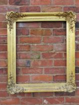 A GILT RECTANGULAR PICTURE FRAME, with foliate moulded detail to each corner, rebate 68 x 55 cm