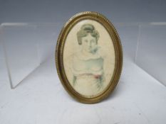A 19TH CENTURY OVAL PORTRAIT MINIATURE OF A YOUNG WOMAN, unsigned, watercolour on paper, framed