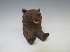 A BLACK FOREST SEATED BEAR INKWELL, the head hinging to reveal a glass inkwell, H 8.5 cm