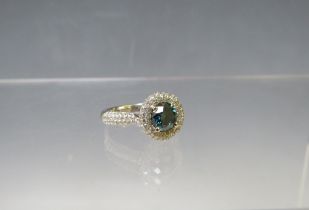 A HALLMARKED 18 CARAT WHITE GOLD BLUE DIAMOND CLUSTER RING, the central brilliant cut blue diamond