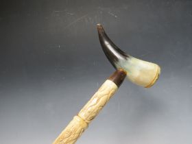 A CARVED BONE WALKING STICK WITH HORN HANDLE, overall L 92 cm