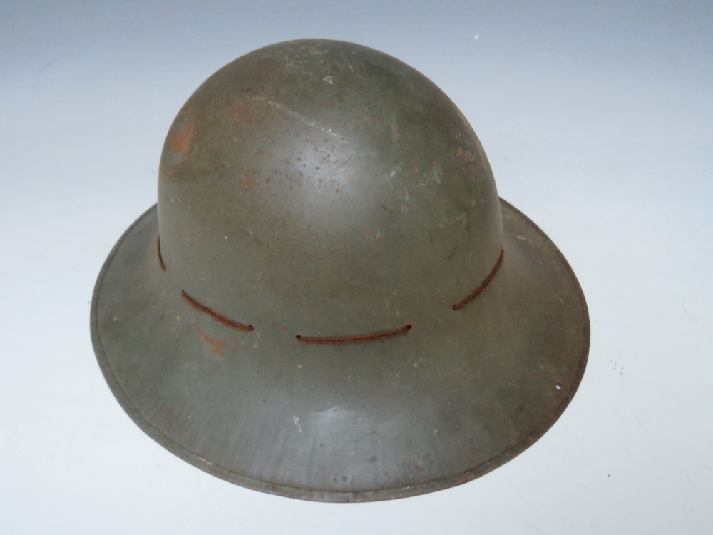 A BRITISH TIN HELMET DATED 1941, with stencilled S.F.P. to the front together with an Eastern - Image 2 of 5