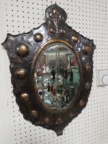 AN USUAL EARLY 20TH CENTURY COPPER SHIELD SHAPED WALL MIRROR, with stylised floral detail to the top