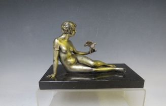 A 20TH CENTURY ART DECO STUDY OF A SILVERED METAL FEMALE NUDE HOLDING A BIRD, raised on a slate