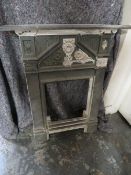 A SMALL VINTAGE CAST IRON FIRE SURROUND
