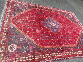 A LARGE EASTERN RED/BLACK WOOLLEN RUG - APPROX 300 x 213 cm