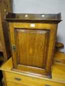 A SMALL ANTIQUE OAK INLAID WALL CUPBOARD WITH FITTED INTERIOR