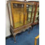 A 20TH CENTURY WALNUT GLAZED TWO DRAWER CABINET ON CABRIOLE LEGS