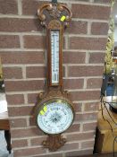 A CARVED OAK ANEROID BAROMETER