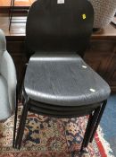 A SET OF FOUR MODERN BLACK PLY EFFECT STACKING CHAIRS TOGETHER WITH A MODERN ARMCHAIR