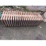 A VINTAGE CAST IRON LOW 21 FIN RADIATOR