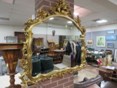 A MODERN GILT SHAPED WALL MIRROR