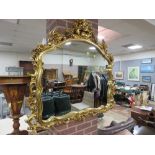 A MODERN GILT SHAPED WALL MIRROR