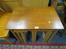 A MID CENTURY TEAK NEST OF TABLES ON CASTORS