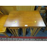 A MID CENTURY TEAK NEST OF TABLES ON CASTORS