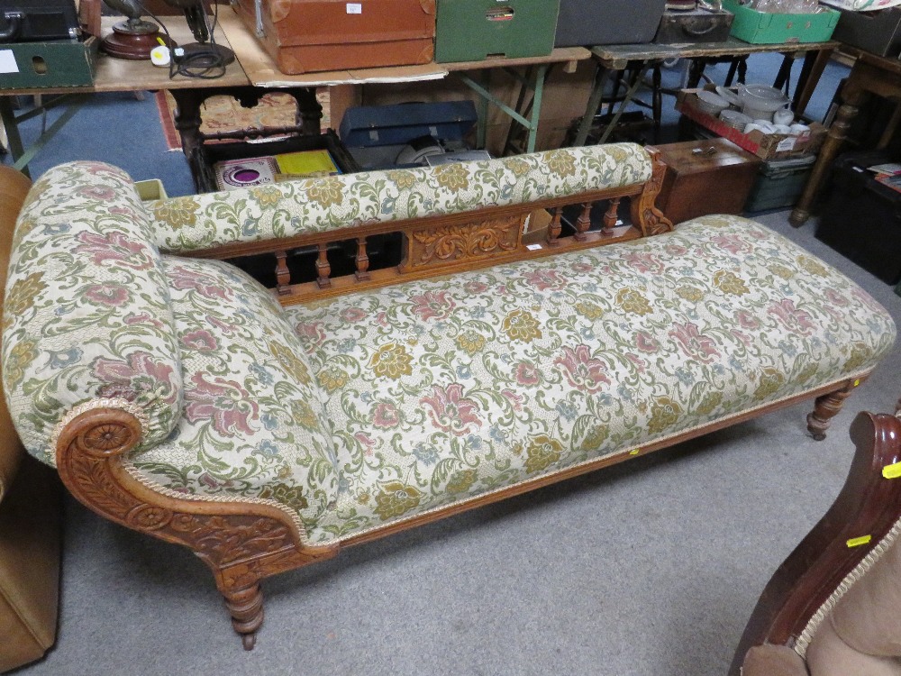 AN EDWARDIAN CARVED OAK CHAISE LONGUE