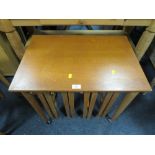 A MID CENTURY TEAK NEST OF TABLES ON CASTORS