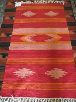 A RED / ORANGE WOOLLEN RUG - 90 X 150 CM