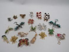 A MIXED BOX OF DECORATIVE BROOCHES