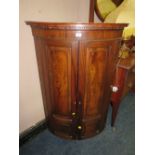 AN ANTIQUE MAHOGANY BOW-FRONT HANGING CORNER CUPBOARD