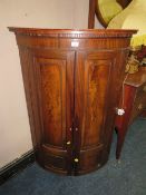 AN ANTIQUE MAHOGANY BOW-FRONT HANGING CORNER CUPBOARD