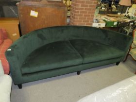 A LARGE MODERN CURVED GREEN SOFA