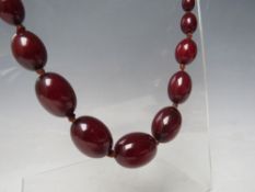 A CHERRY RED FATURAN AMBER GRADUATED OVAL BEAD NECKLACE, approx L 70 cm, approx weight 51 g