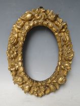 A 19TH CENTURY SMALL OVAL CARVED WOODEN DECORATIVE GOLD FRAME, frame W 4.5 cm, rebate 17 x 12 cm