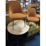 A MODERN CIRCULAR TABLE WITH TWO ORANGE CHAIRS