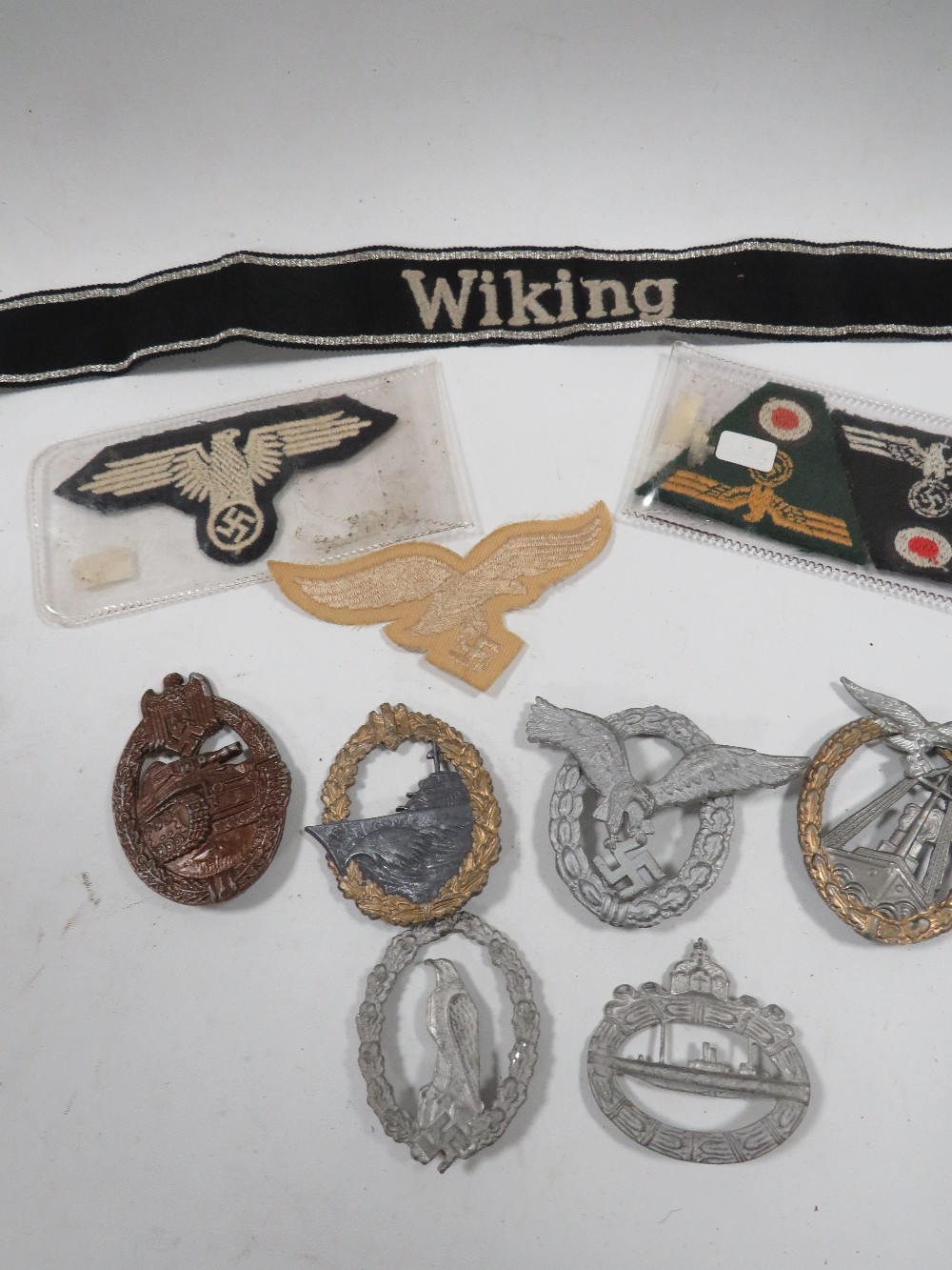 A COLLECTION OF MILITARY TYPE BADGES AND PATCHES