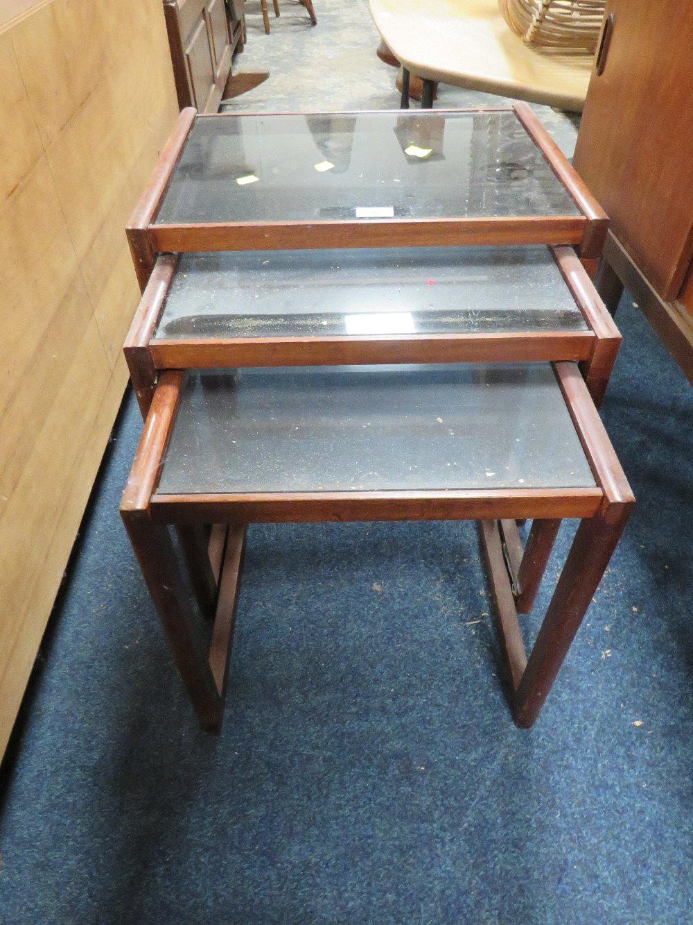 A MID CENTURY NEST OF TABLES WITH GLASS TOPS A/F