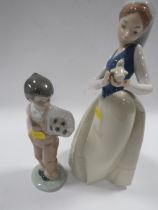 A NAO FIGURE OF A GIRL HOLDING A BIRD TOGETHER WITH A SMALL NAO FIGURE OF A BOY HOLDING A FOOTBALL