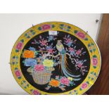 A LARGE ORIENTAL STYLE CHARGER DECORATED WITH A TROPICAL BIRD BY A BASKET OF FLOWERS