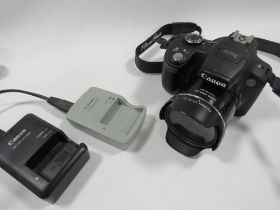 A CANON DIGITAL CAMERA SX50 HS TOGETHER WITH A BATTERY AND CHARGER (UNCHECKED)