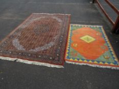 A large Eastern woollen rug together with a smaller modern woollen rug