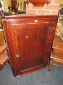 A Georgian oak panelled hanging corner cupboard