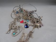 A bag of assorted costume jewellery to include silver examples