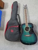 A modern acoustic guitar in blue/green finish with travel case included