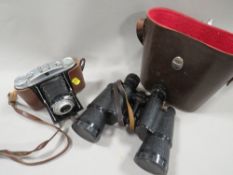 A pair of vintage binoculars plus a camera