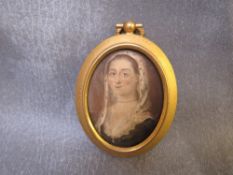 A 19TH CENTURY OVAL PORTRAIT MINIATURE OF A LADY, wearing a white head covering, unsigned,