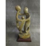 A MODERN BRITISH SCHOOL ABSTRACT SCULPTURE, depicting three figures on a wooden base, H 30 cm