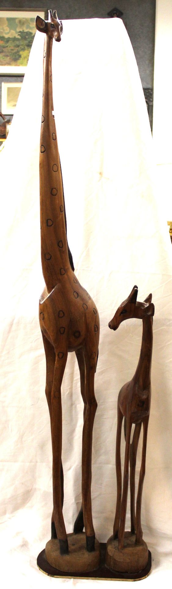 Paar hohe Holz-Giraffen, neuzeitl., beide auf Platte befestigt, ca. H-148cm B-33,5cm T-18,5cm. Nur 