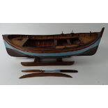 Holzmodell eines Ruderbootes, Handarbeit, auf Ständer, H-14 cm, L-33 cm, beide Ruder anbei