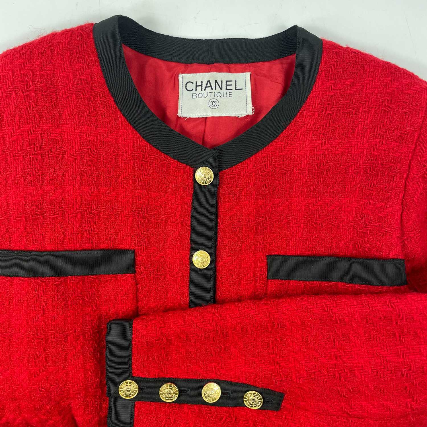 A Chanel 1980's red boucle jacket with gold plated buttons and black trim. - Image 7 of 9