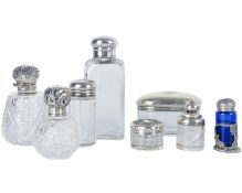 A collection of eight assorted silver-topped dressing table jars.