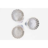 An Edwardian silver pair of scallop shell butter dishes by James Deakin & Sons, and one other.