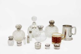 A collection of cut glass silver lidded scent bottles.